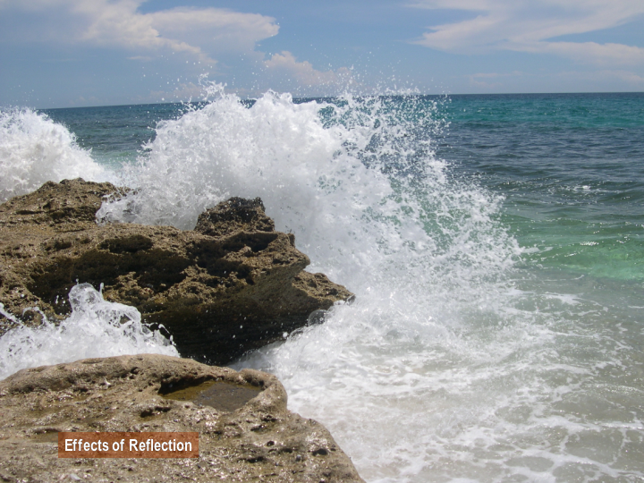 photograph showing the effects of wave reflection as waves break on a rock